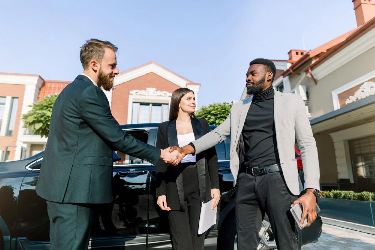 Rental agent handing over car keys to a couple next to an SUV in Australia